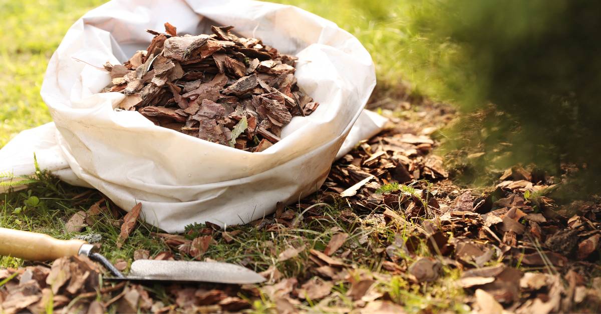 Sack of Mulch and a Trowel in Garden